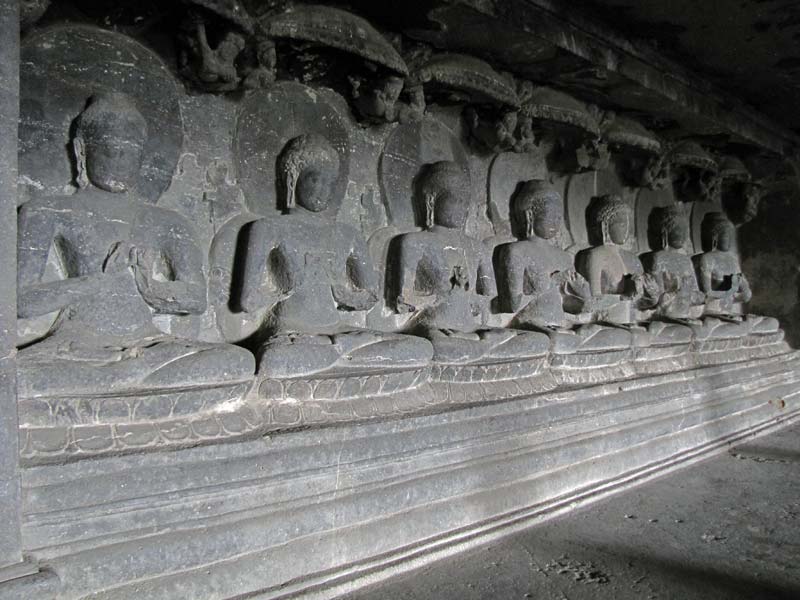 Aan de andere zijde van de kloosterhal: zeven boeddhabeelden, waarschijnlijk in de Dharmachakra Mudra pose die het leren symboliseert.