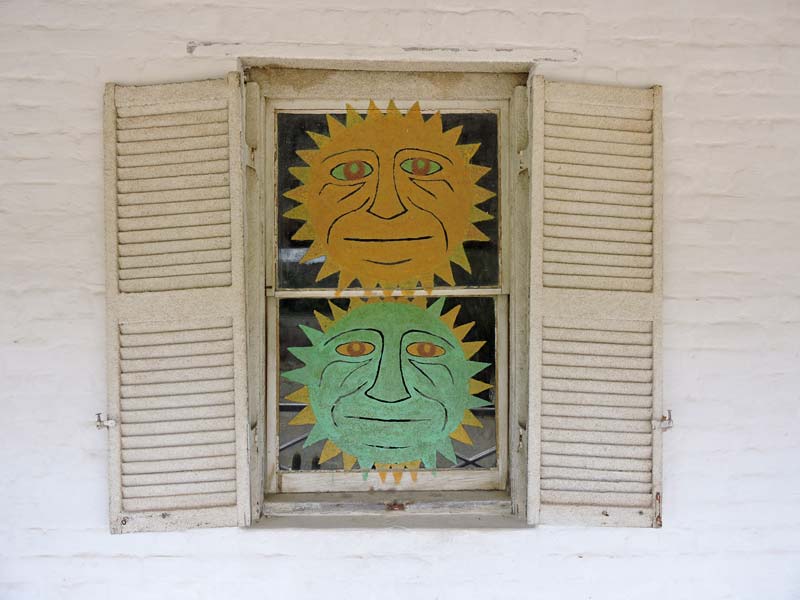 Een van de ramen met zonnegezichten.